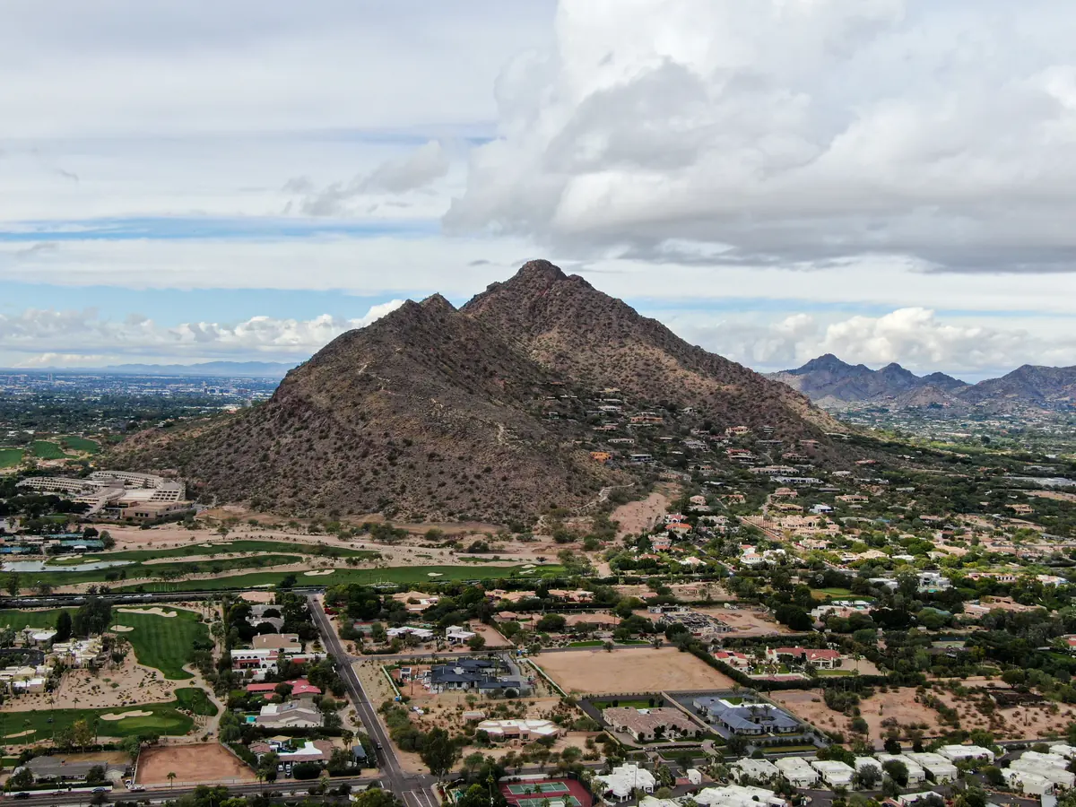 Aerial view of Camelback Mountain rising above Scottsdale and Phoenix neighborhoods with backyard pools