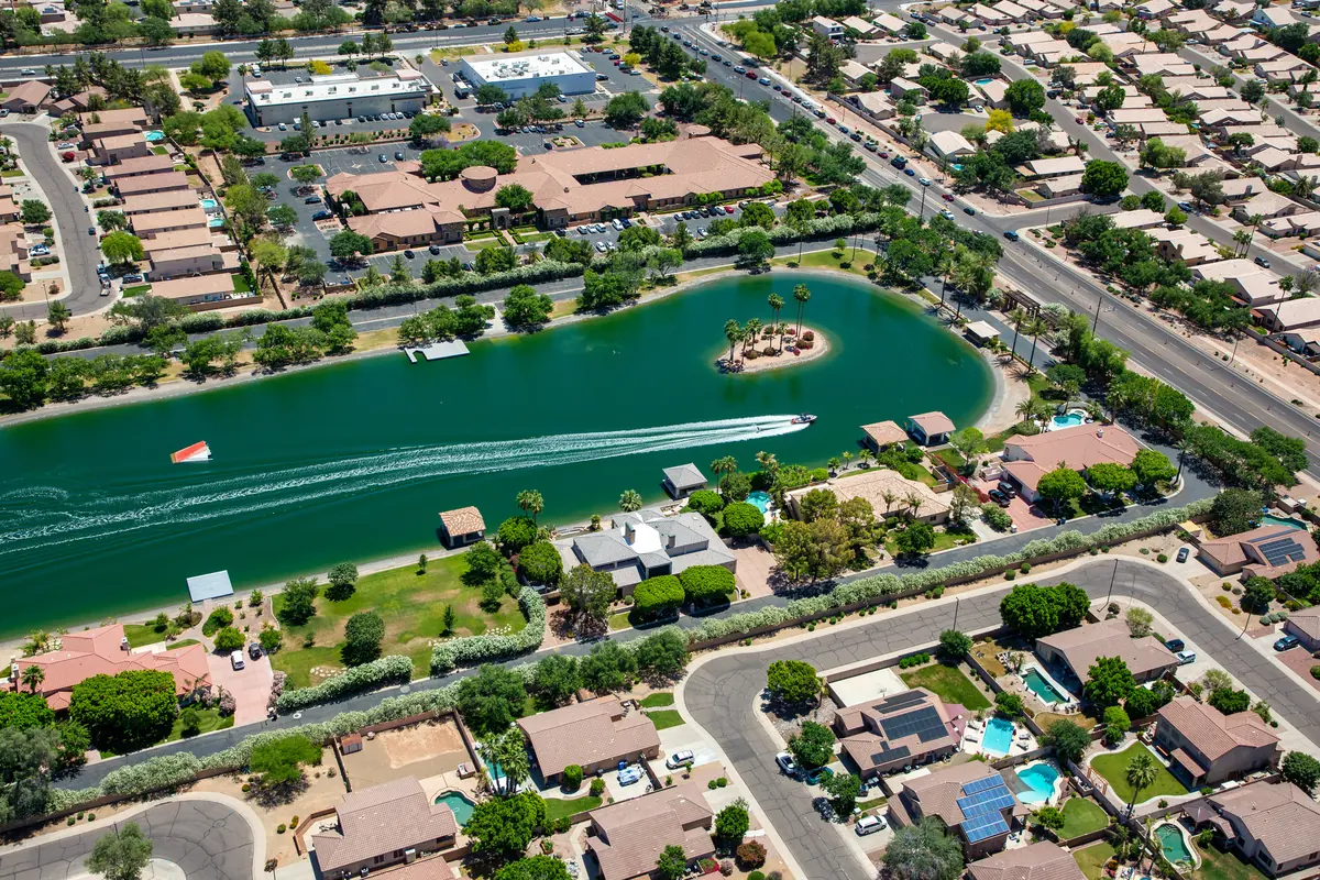 Aerial view of a lakefront residential community with turquoise water, parks and tree-lined streets in the Scottsdale area