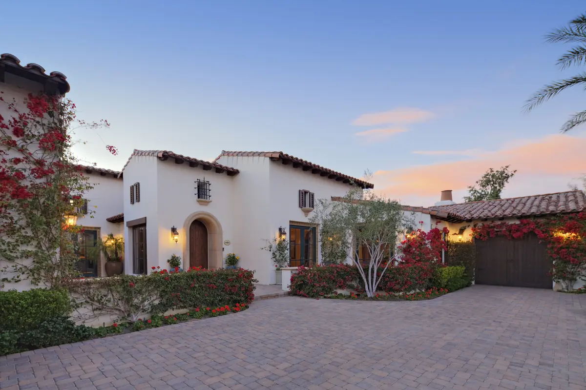 Front exterior of a white Spanish-style Scottsdale luxury home with a terracotta tile roof and desert landscaping